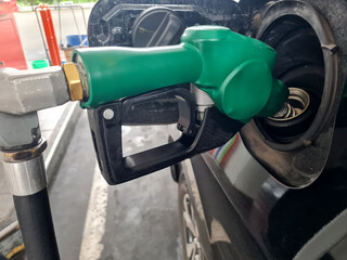 Car refueling at gas station. Refuel with petrol gasoline. Gasoline pump filling fuel nozzle in car fuel tank at gas station. Gasoline industry and services. Concept of petrol prices and oil crisis.