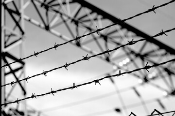 restricted area high fence with barbed wire and very dramatic  effect in black and white colors - obrazy, fototapety, plakaty