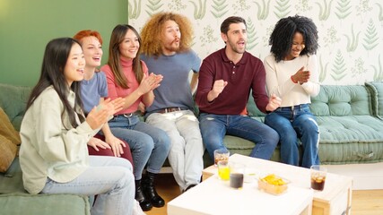 Group of friends celebrating something they are watching on TV