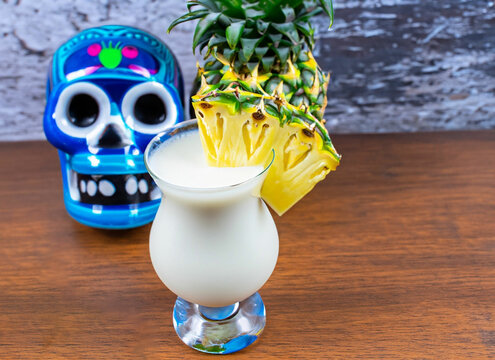 milky coattail garnished with pineapple next bule Mexican skull