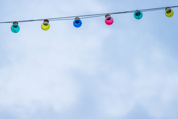 Christmas garland light bulbs on blue and cloudy sky background. Wedding ceremony decoration....