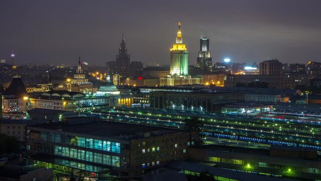 Evening top view of three railway stations day to night transition timelapse at the Komsomolskaya square in Moscow, Russia. Trains on tracks. Stalin skyscrapers on background. Aerial view from rooftop