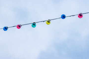Straight line of Christm garland light bulbs on cloudy sky background. Wedding ceremony decoration....
