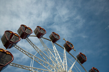  Ferris wheel on  blue sky background, with metal beam guides and passenger booths.