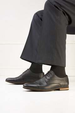 male legs in classic shoes. sitting man in boots and trousers. businessman