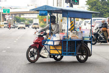 Fototapeta na wymiar The drinks vendor drives a motorbike with a mobile stand, Bangkok, Thailand