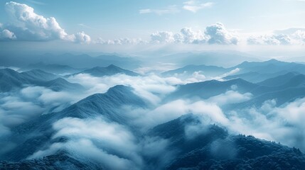   A stunning aerial shot of majestic mountains shrouded by clouds in the foreground against a serene backdrop of a clear blue sky dotted with fluffy white clouds