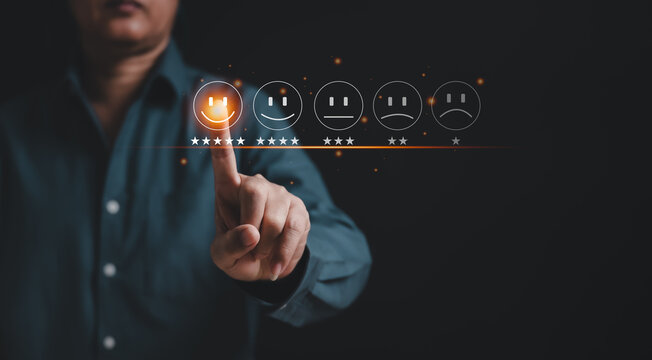 Businessman pressing smiley face emoticon on the virtual touch screen. Customer service evaluation and satisfaction concept. The rating is very impressive.
