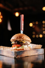 burger on a wooden table in a bar with knife
