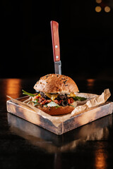 burger with vegetables on a wooden table in a bar