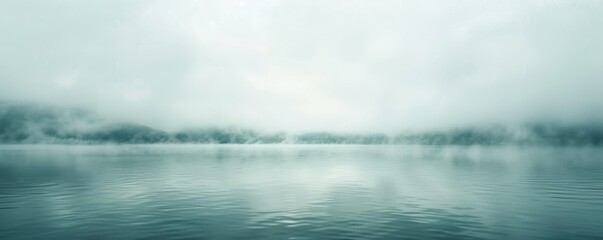 Wide panoramic view of a tranquil lake shrouded in mist with forested hills - obrazy, fototapety, plakaty