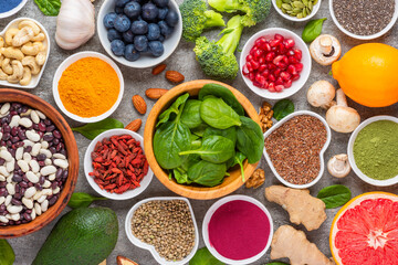 Assortment of various vegan super foods for clean eating antioxidant detox diet. Fruits, vegetables, seeds, powder, spinach, ginger, berries, beans, mushrooms and nuts. Balanced nutrition. Top view