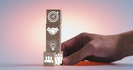 the concept of team work to be success, wooden blocks with icons and man hand putting icon the most...