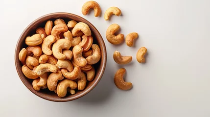 Fotobehang Top view of kaju or cashew nut in a bowl with a big space for text or product in a studio white backdrop, Generative AI. © Noobs