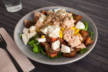 Fish salad with canned tuna and corn, tomatoes and arugula