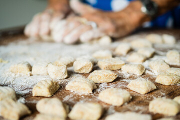 Fototapeta na wymiar senior housewife making Italian pasta gnocchi traditional 