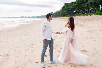 Young white newlyweds on beach holding hands