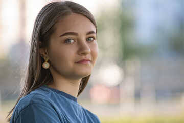 Portrait of a young beautiful long-haired girl in an urban environment.