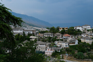 Fototapeta na wymiar Fortress in Gjirokastra a huge stone building on a high mountain in Albania with a clock the history of the Middle Ages a beautiful view from the stone city to the ancient village