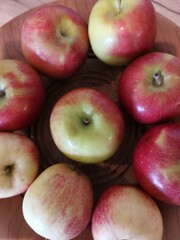 red and yellow apples on a wooden plate 