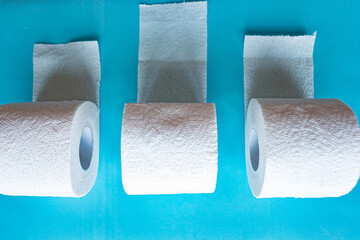 Three toilet paper rolls on blue background. Quarantine 2020 concept