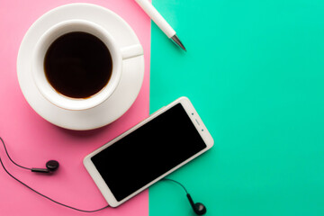 Coffee cup and mobile phone with black mockup screen on color background. Minimal concept