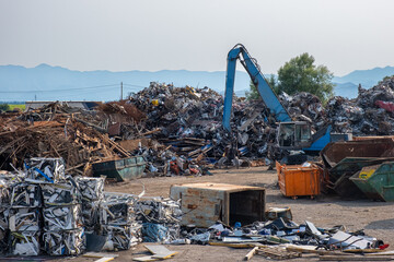 Clow crane picking up scrap metal at recycling center for metal, aluminum, brass, copper, stainless steel in junk yard. Recycling industry. Environment, Earth day and zero waste concept - 778905060