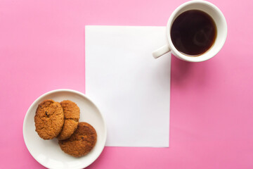 Flat lay photo with coffee cup, raisins cookies and white mockup blank on pink background....