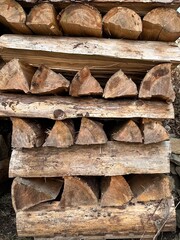 Logs stacked on top of each other form a neat and organized pile in a forest setting