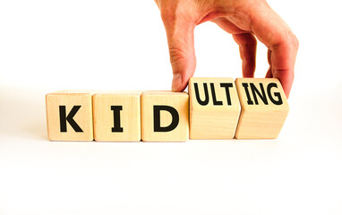 Kid or kidulting symbol. Concept words Kid or Kidulting on wooden cubes. Beautiful white table white background. Psychologist hand. Healthy lifestyle and kid or kidulting concept. Copy space.