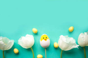 White tulips and toy chicken on green background. Easter concept, copy space for the text