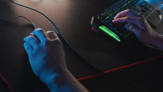 Gamer plays on professional gaming keyboard RGB lighting animation mouse. E-sport tournament at computer club, cyber team, video games. Skill. Real-time strategy, tactical shooter. Modern equipment