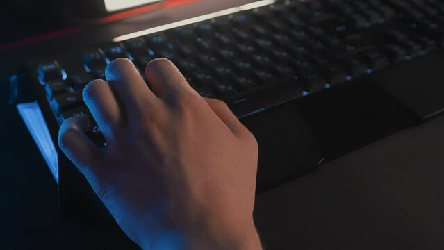 Fingers press WASD keys on gaming RGB keyboard. Cyber sport tournament computer club Professional E-sport championship. Gamer plays video game on PC. Multiplayer online tactical first-person shooter
