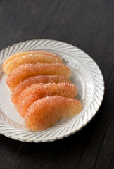 Red pomelo pulp on a white plate