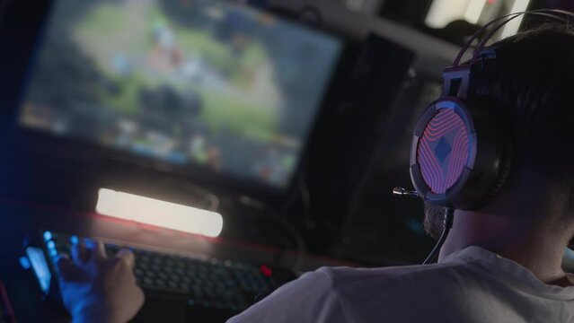 Esports tournament Adult bristly gamer in headset plays video game on PC at computer club, real-time strategy RTS multiplayer online battle competition. Skill. Cyber sport championship. Gaming monitor