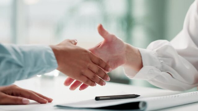 Signature, shaking hands and business people with deal, contract or agreement in office at desk. Handshake, closeup and consultant signing document for b2b partnership, acquisition or negotiation