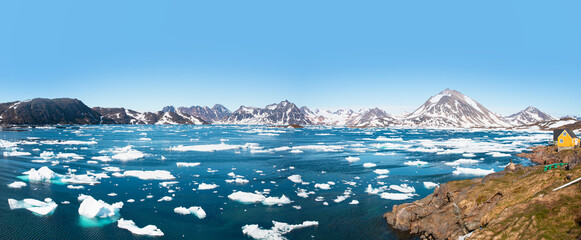 Panoramic view of colorful Kulusuk village in East Greenland - Kulusuk, Greenland - Melting of a iceberg and pouring water into the sea