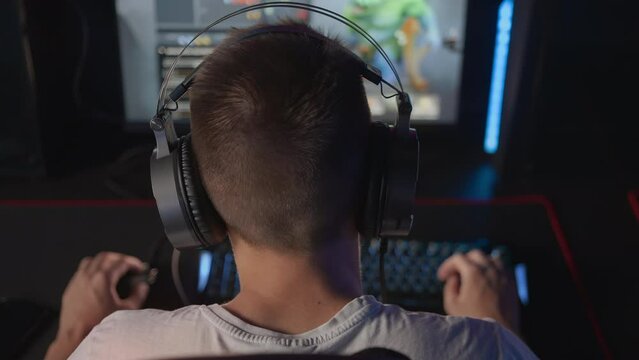 Cyber sport tournament Gamer in headset plays video game on PC at computer club, real-time strategy RTS multiplayer online battle competition. Skill. Gaming earphones Professional E-sport championship