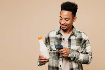 Young smiling happy man wearing grey shirt hold food product blank milk bottle, reader for scanning...