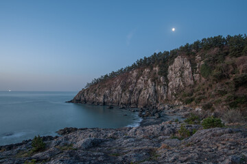 Night view of the coast with rocks visible
