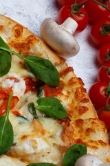 Pizza with spinach, cherry tomatoes and gorgonzola cheese on a light background