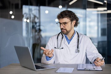 Healthcare professional in white lab coat engaged in a telehealth call, providing remote...