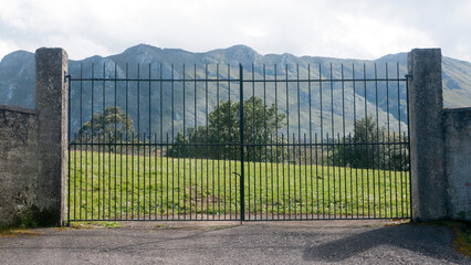 Puerta de finca rural y montañas al fondo - obrazy, fototapety, plakaty