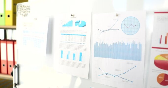 A business woman hangs documents for flipchart, a close-up. Schedule reports and digrams, slowmotion