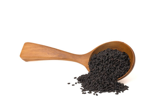 Black Sesame Seeds  in a wooden spoon. isolated on a white background.