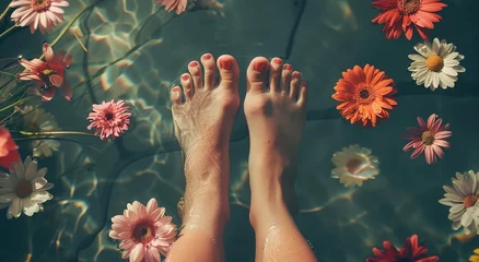 Poster a person's feet in water with flowers floating around them © progressman