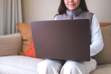 Closeup image of a young woman working on laptop computer at home