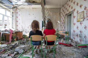 Uczennice w zniszczonej przez wojnę szkołę w Donbasie na Ukrainie - obrazy, fototapety, plakaty