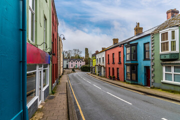A view past colourful houses towards the castle ruins on the main road into Narberth, Pemborkeshire, Wales in Springtime