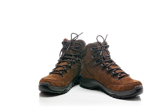 A pair of new brown suede walking or hiking boots isolated on a white background with tied laces.
